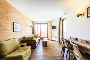 sala de estar con sofá y mesa en Résidence Les Temples du Soleil - maeva Home - Appartement 4 pièces 8 perso 65 en Val Thorens