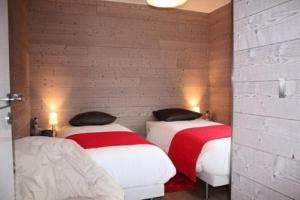 2 camas con sábanas rojas y blancas en una habitación en Gîte de France à Saint-Germain-Lavolps 3 épis - Gîte de France 4 personn 314, 
