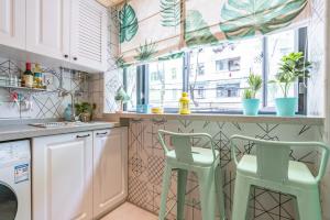 a kitchen with a counter with two green stools at Shanghai Hills&XING 1882 Homestay Near Line2 & Line12 West Nanjing Rd in Shanghai +13 photos