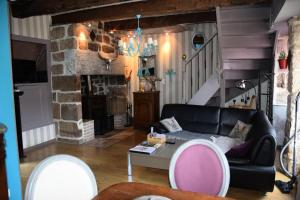 a living room with a black couch and a fireplace at Gîte de France Chirac du midi corrézien 3 épis - Gîte de France 6 personnes MAE-0324 in Turenne