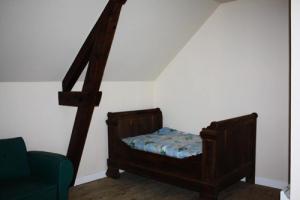 a bedroom with a bed and a green chair at Gîte de France La cascade du doustre 2 épis - Gîte de France 6 personnes MAE-5584 in Neyrat