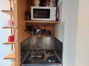 a kitchen with a sink and a microwave at Résidence Nova - Studio 3 personnes, proche des pistes et des commerces, au cœur de la station d’Arc 1800 dans le village des Villards MAE-1845 in Arc 1800