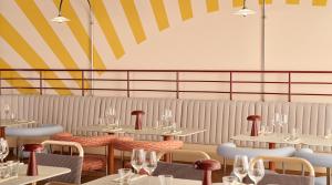 een restaurant met tafels en stoelen en een gestreepte muur bij Original Sokos Hotel Royal in Vaasa