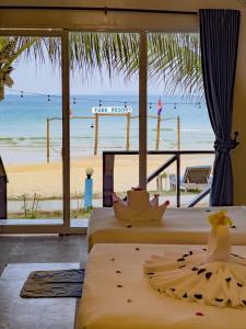2 łóżka w pokoju z widokiem na plażę w obiekcie Tube Resort w mieście Koh Rong Sanloem