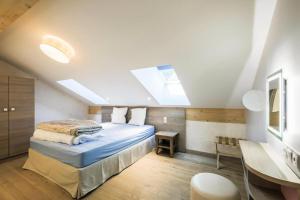 a bedroom with a bed and a desk in a room at Résidence Premium L'Hévana - maeva Home - Appartement 4 pièces 8 personnes Prestige MAE-6261 in Les Allues +30 photos