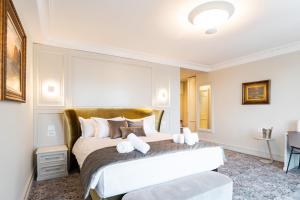 een slaapkamer met een groot bed met een gouden hoofdeinde bij VIZUALIZA Residence Hotel in Plovdiv