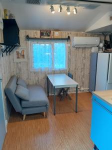 - un salon avec une table, une chaise et un réfrigérateur dans l'établissement mobil home dans camping 3 etoiles mas de lastourg avec piscine,snack,, à Villefranche-de-Conflent