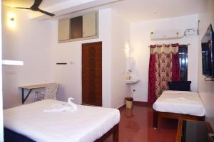 duas camas num quarto com um cisne em Cardiff palace em Pondicherry