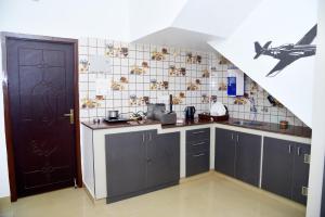 a kitchen with gray cabinets and a plane on the wall at Cardiff palace in Puducherry