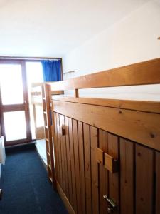 drewnianym łóżkiem piętrowym w pokoju z oknem w obiekcie Résidence Tournavelles - Appartement 2 pièces 7 personnes en duplex, au pied des pistes et des commerces, proche de l'ESF et de la garderie dans le villa MAE-1875 w mieście Arc 1800
