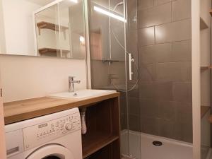een badkamer met een wasmachine en een douche bij Residence Arcs - Pièces 73 in Arc 1600