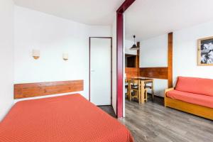 - une chambre avec un lit rouge et une table dans l'établissement L'Aiguille - maeva Home - Appartement 2 pièces 5 personnes Confort 19, à Chamonix-Mont-Blanc