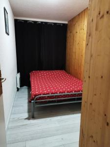 a red bed in a room with a black wall at Résidence Rond-Point-pistes I - 3 Pièces pour 8 Personnes 224 in Orcières