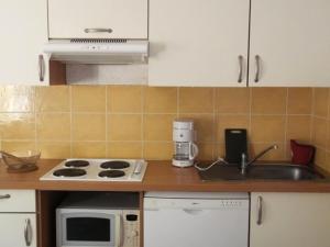 a kitchen with a sink and a stove and a microwave at Résidence Rond-Point-pistes I - 2 Pièces pour 6 Personnes 174 in Orcières