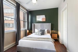 a bedroom with a bed and a green wall at Spacious Modern Condos near French Quarter in New Orleans