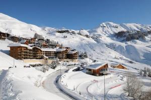 un lodge de ski dans la neige sur une montagne dans l'établissement Résidence Rond-Point-pistes I - 2 Pièces pour 8 Personnes 194, à Orcières