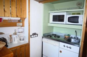małą kuchnię ze zlewem i kuchenką mikrofalową w obiekcie Résidence Archeboc - Appartement de charme en duplex, équipé pour 6 personnes, proche des pistes dans le village de Charmettoger à Arc 1800 MAE-1887 w mieście Arc 1800 +12 zdjęć