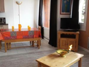 ein Wohnzimmer mit einem Tisch und einem TV in der Unterkunft Résidence Rond-Point-pistes I - 3 Pièces pour 8 Personnes 254 in Orcières