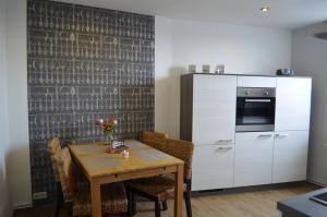 una cucina con tavolo, sedie e frigorifero di Ferienwohnung Edelweiss a Bad Wilsnack