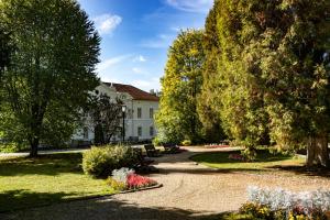 un jardin avec un bâtiment, des arbres et des fleurs dans l'établissement Melik, à Borsec