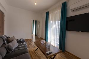 salon z kanapą i stołem oraz dużym oknem w obiekcie Magesa Suites w mieście Antalya
