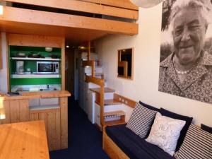 een woonkamer met een bank en een foto van een oma bij Résidence Alliet - Studio pour 5 Personnes 04 in Arc 1800