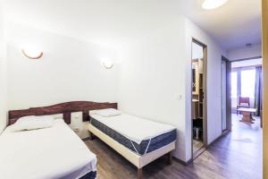 a bedroom with two beds and a mirror at Résidence Les Bergers - maeva Home - Studio 4 personnes - Sélection MAE-0234 in LʼHuez +19 photos