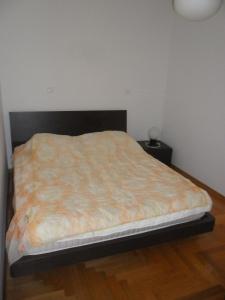 a bed in a bedroom with a wooden floor at Apartment Lela in Pula