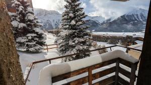 a snow covered balcony with a snow covered tree at Résidence Rond-point-pistes I - Studio pour 6 Personnes 281 in Orcières