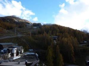 a view of a mountain with trees and a building at Résidence ORR DES CIMES - Studio pour 4 Personnes 554 in Les Orres