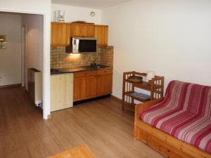 a living room with a kitchen and a couch in a room at Résidence ORR DES CIMES - Studio pour 4 Personnes 554 in Les Orres