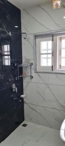 斯利那加的住宿－WOODENVILLE，浴室设有黑色和白色的大理石墙壁和窗户。