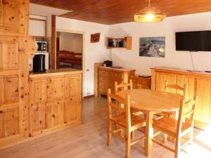 a kitchen and dining room with a wooden table at Résidence L'HORIZON - Studio pour 4 Personnes 574 in Les Orres