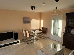 ein Wohnzimmer mit einem Tisch, Stühlen und einem TV in der Unterkunft Apartment Am Jakobsweg in Erfurt
