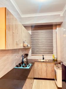 a kitchen with wooden cabinets and a stove top oven at Pishon Home in Dar es Salaam