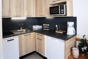 a kitchen with a sink and a counter top at Résidence ORR DES CIMES - Studio pour 4 Personnes 594 in Les Orres