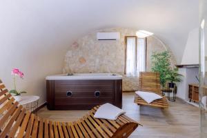 a bathroom with a tub in a room with chairs at Le Case di Maggie in Isolabona