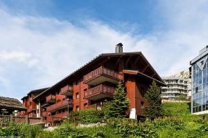 a large red building with a rooftop at Résidence L'Ecrin des Neiges - maeva Home - Appartement 4 Pièces 8 Personnes - Sélection MAE-2873 in Tignes