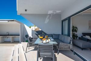 ein Wohnzimmer mit einem Tisch und einem Sofa in der Unterkunft Villa Summer side by Istrialux in Marina