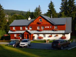 a red barn with cars parked in front of it at Chalupa U Beranů in Harrachov
