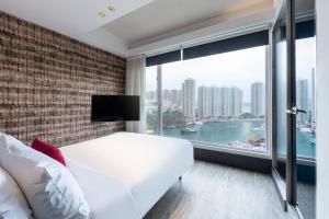 ein Schlafzimmer mit einem weißen Bett und einem großen Fenster in der Unterkunft The Aberdeen Harbour by Ovolo in Hongkong
