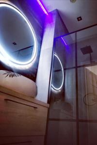 a bathroom with a round mirror and a sink at Apartament Roku 2024' - JELEŃ & NATURA in Kudowa-Zdrój