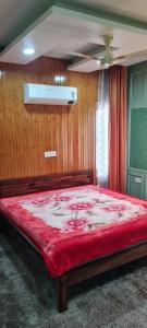 斯利那加的住宿－WOODENVILLE，一间卧室配有一张带红色毯子的大床