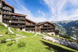 a hotel on a hill with mountains in the background at Résidence Les Brigues - maeva Home - Appartement 2 Pièces 6 Personnes - Con 98 in Courchevel