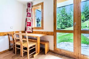 a table and chairs in a room with a window at Résidence Les Brigues - maeva Home - Appartement 2 Pièces 6 Personnes - Con 98 in Courchevel
