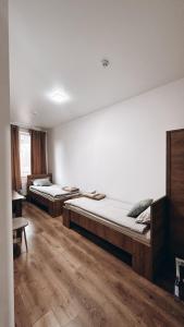 2 camas en una habitación con suelo de madera en Hotel Dovha, en Leópolis