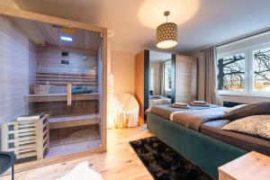 a bedroom with a large bed and a glass wall at Apartman Dior - sauna, self check in in Belišće