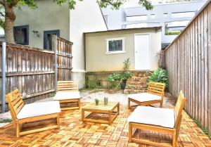 a patio with chairs and a table and a fence at Family Friendly 3 Bedroom House Glebe 2 E-Bikes Included in Sydney