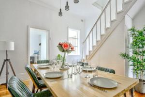 a dining room with a wooden table and green chairs at Family Friendly 3 Bedroom House Glebe 2 E-Bikes Included in Sydney