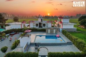 Jhirna的住宿－Hriday Bhoomi with Pool at Jim Corbett by StayVista，享有带游泳池的房屋的空中景致